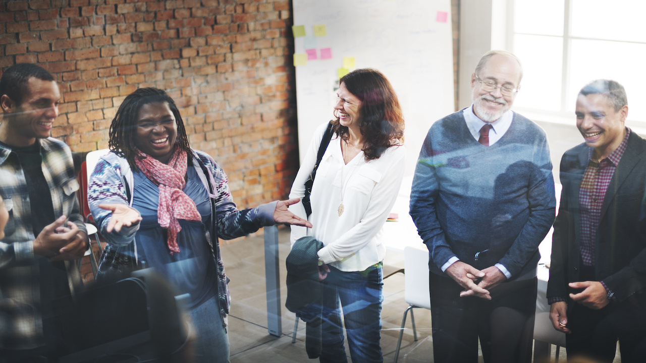 An image of a group of diverse team members laughing and smiling